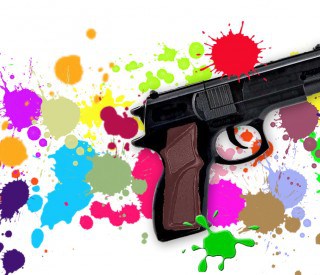 Toy gun on paint-splattered background