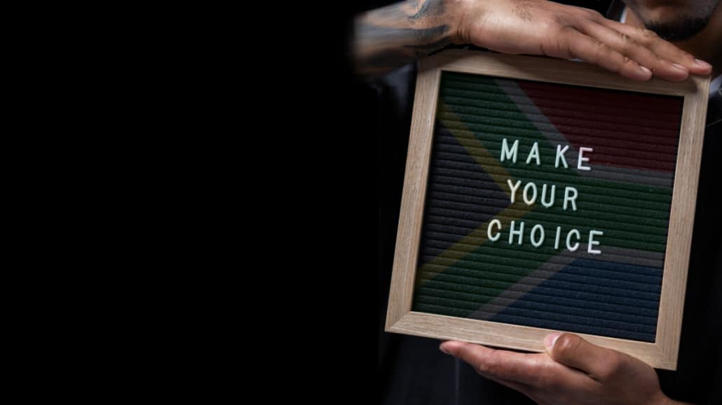 Man holding sign saying Make Your Choice