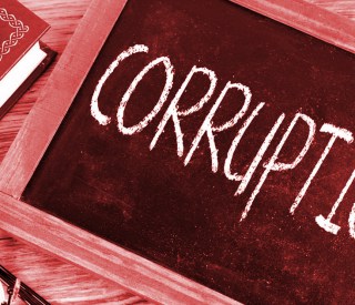 The word 'corruption' written in chalk on a small chalkboard