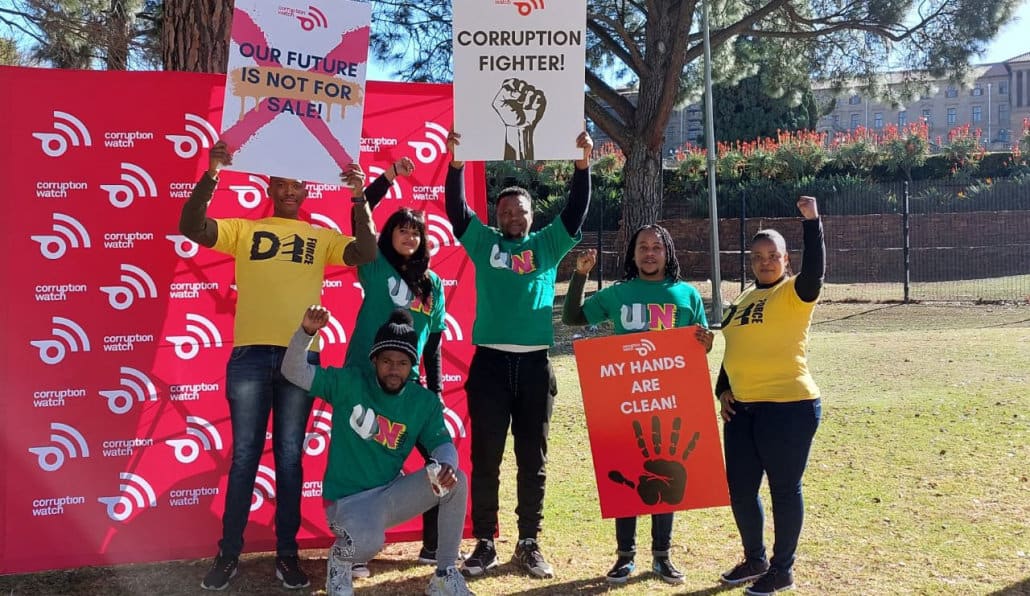 YOung people holding anti-corruption placards