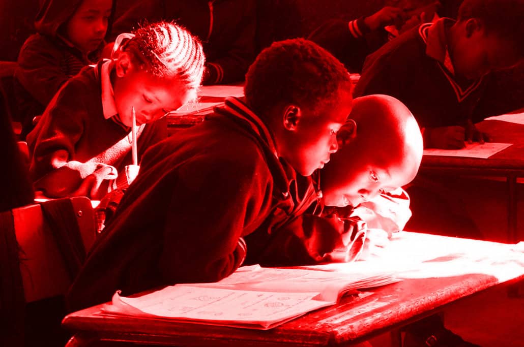 Schoolchildren sitting at a desk in a classroom