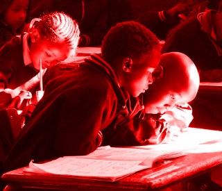 Schoolchildren sitting at a desk in a classroom