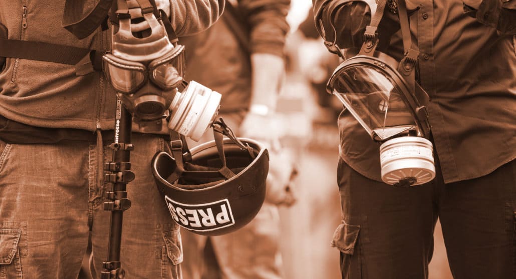Journalists wesring protective gear