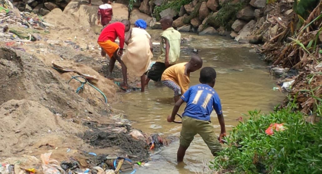 Photo of people taking water from an unclean stream