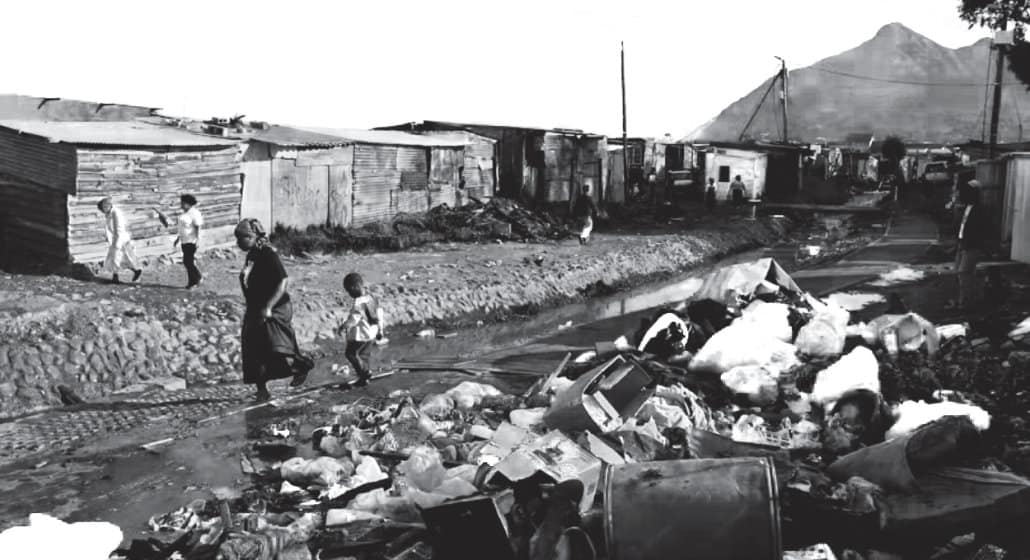 A photo of refuse and garbage piled in a township street