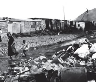 A photo of refuse and garbage piled in a township street