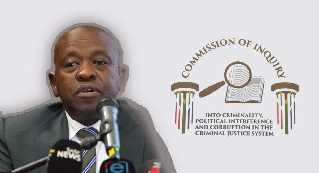 Justice Mbuyiseli Madlanga, next to the banner and logo of the Madlanga commission into criminality in the criminal justice system