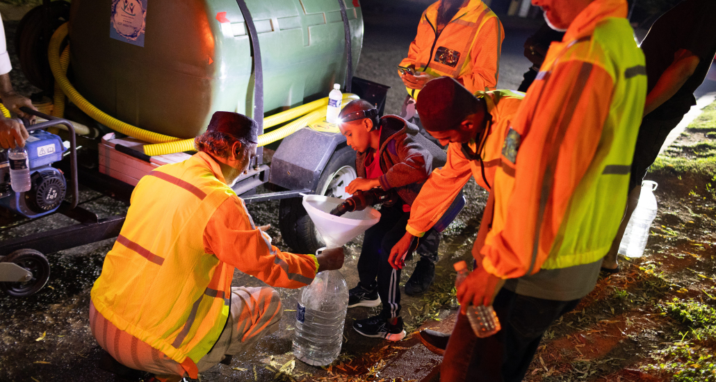 Twelve-year-old volunteer Ismail Tayob of Ridgeway in Johannesburg helps members of the Southern Suburbs Community Forum and Water Project fill water containers. Photos: Alaister Russell